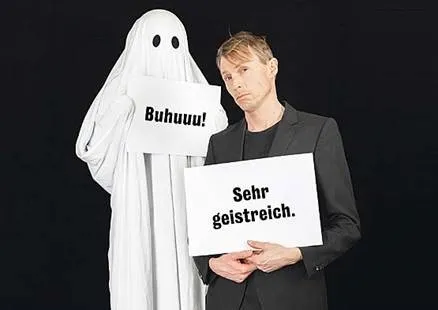 Mann und Geist schauen in die Kamera mit Schildern in der Hand