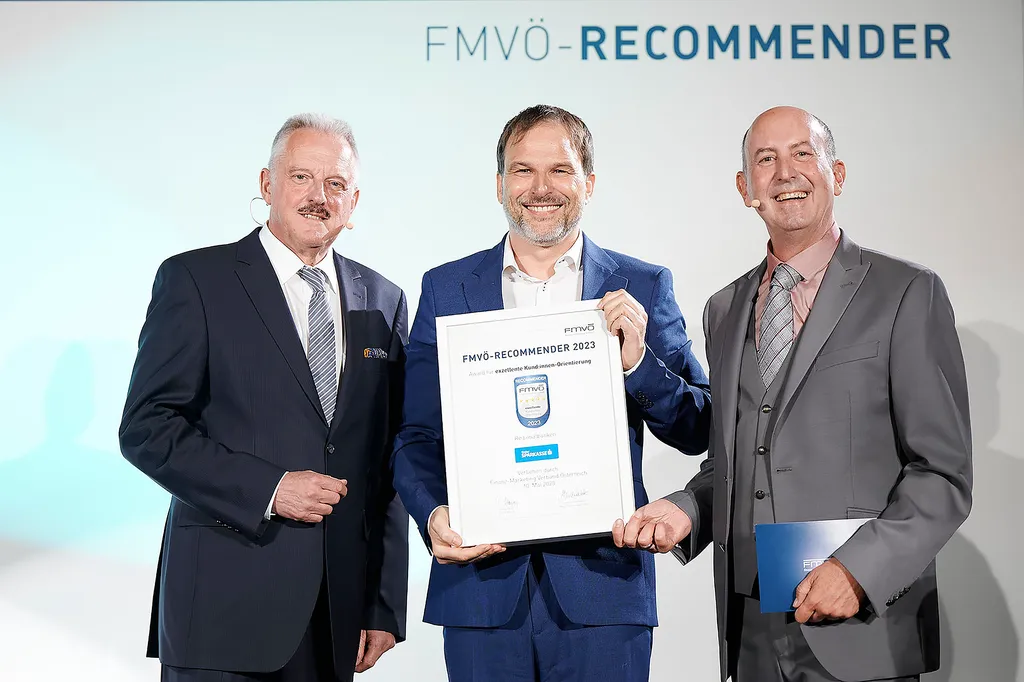 Drei Herren posieren mit Recommender-Award-Gütesiegel