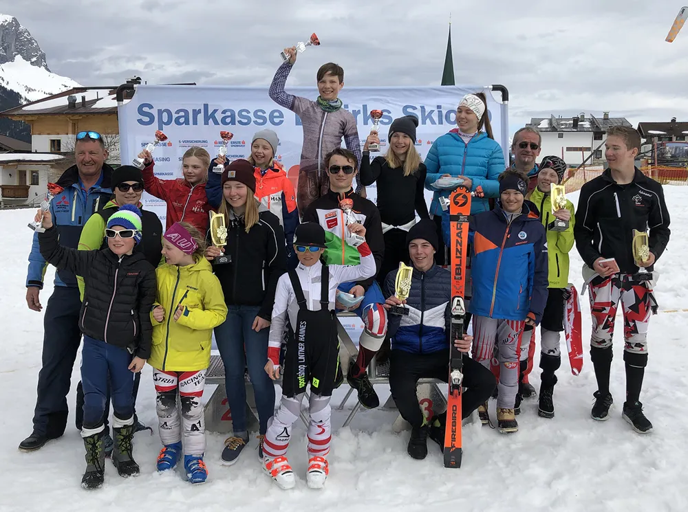 jugendliche Skifahrer glücklich mit Pokal in der Hand