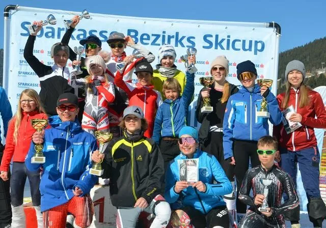 Gruppenfoto des Sparkasse Bezirks Skicup, Kinder lachen in die Kamera mit Pokalen