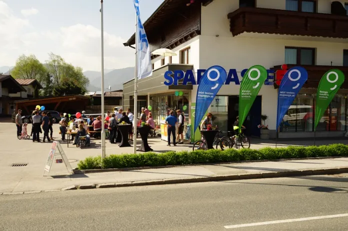 sitzende Personen vor der Sparkasse 