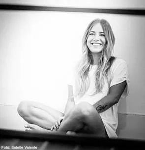 Schwarz weißes Bild mit einer lachenden Frau sitzend am Boden