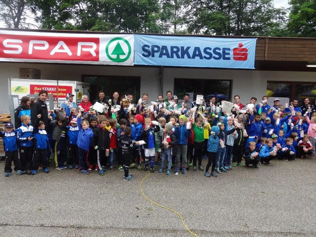 Gruppenbild von Kindern vor Sparkasse und Spar Plakat