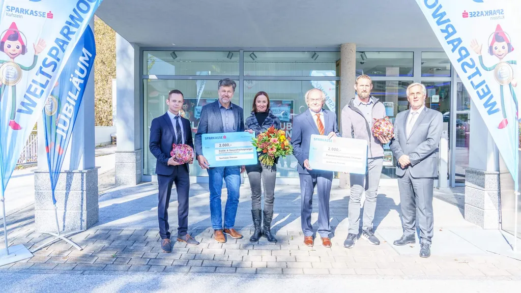 6 Personen im freien mit Blumenstrauß und Scheck in der Hand