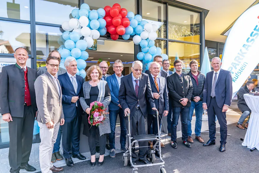 Personen lachend vor Sparkasse Eingang