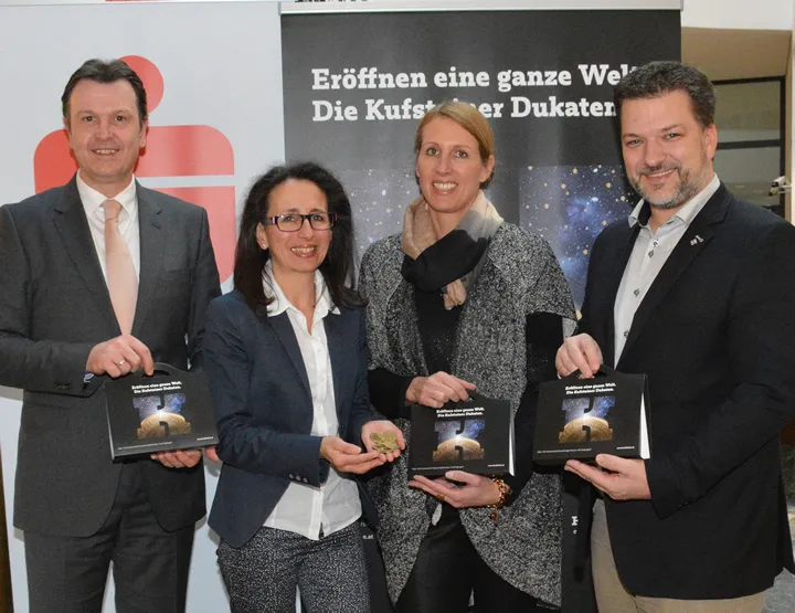 zwei Frauen und zwei Männer halten Kufsteiner Dukaten Werbung in der Hand 