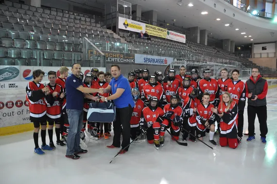 Prall gefüllte Spieletasche wird an die jubelnden Haie übergeben.