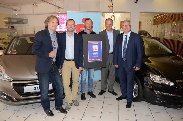 fünf stehende Personen zwischen zwei Autos 
