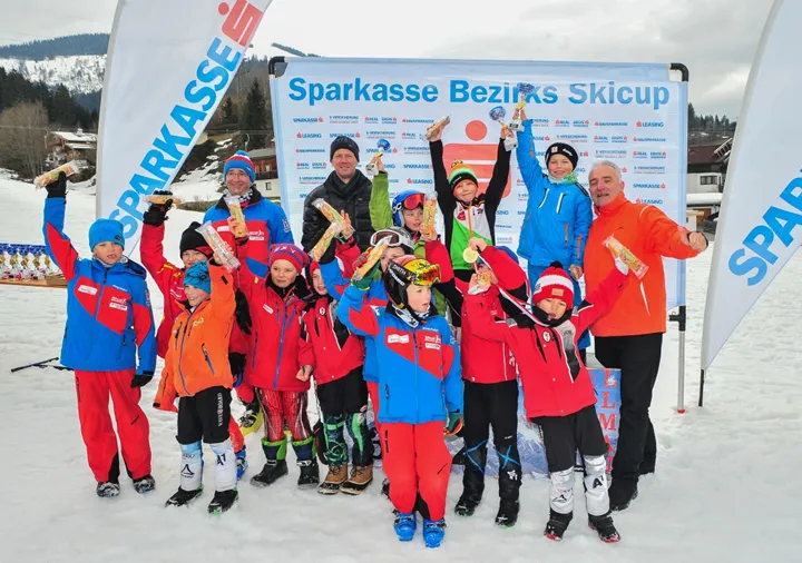 viele Kinder im Skianzug mit Medaille in der Hand