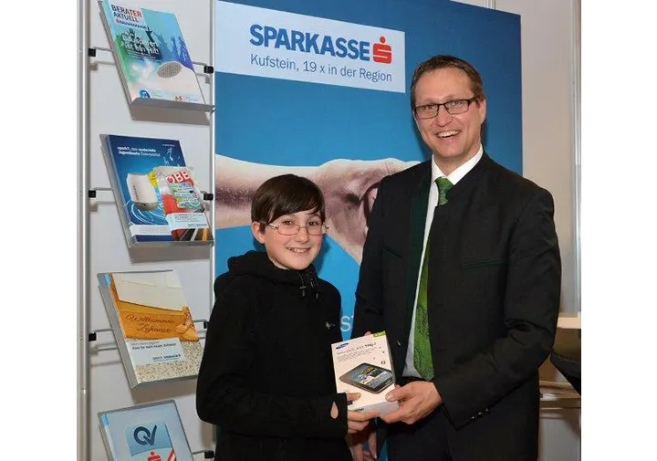 ein Mann und ein Kind halten gemeinsam einen iPod in der Hand