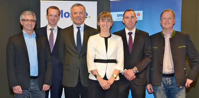 fünf Männer und eine Frau lachen stehend in die Kamera