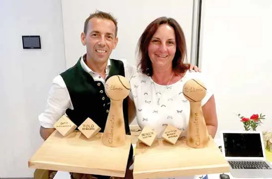 Mann und Frau halten jeweils Holzkunstwerke in der Hand