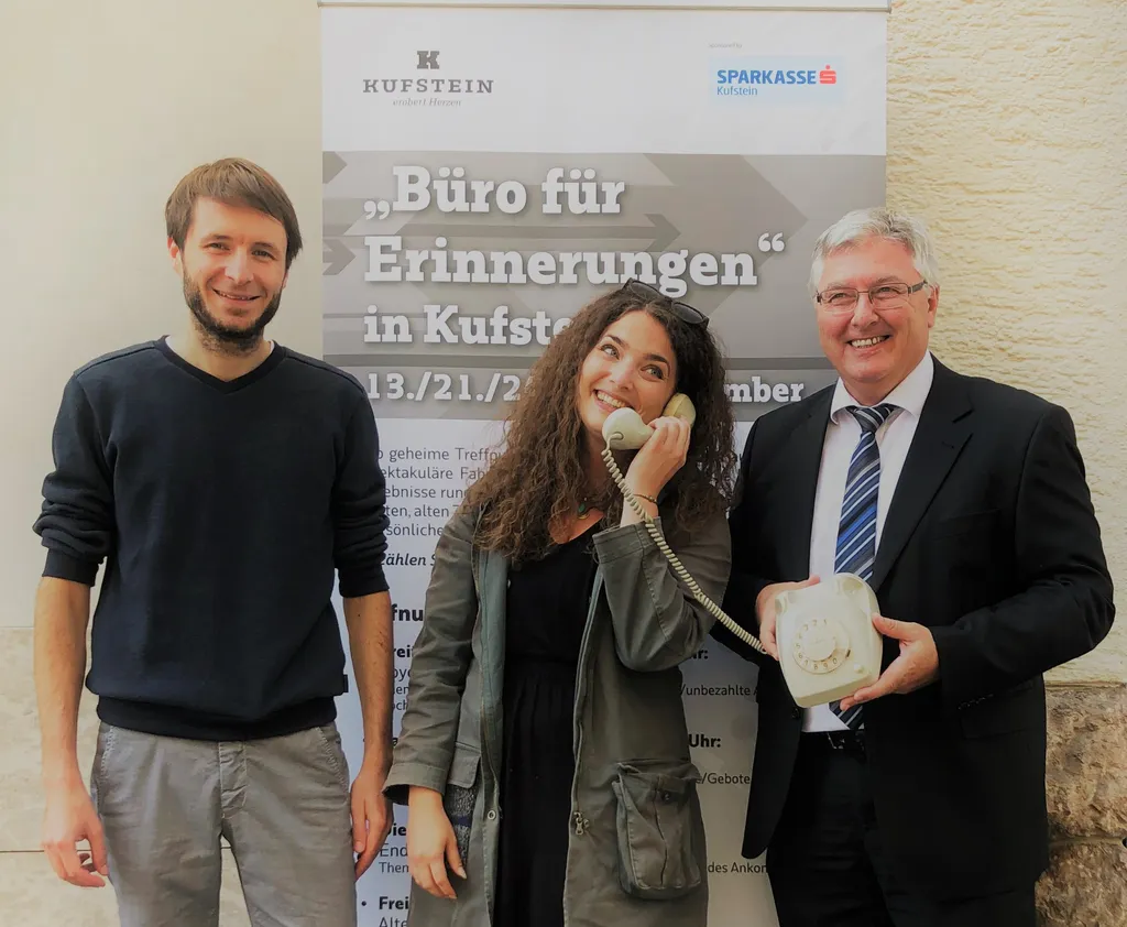 Frau mit Telefon bei dem Ohr und zwei Männer