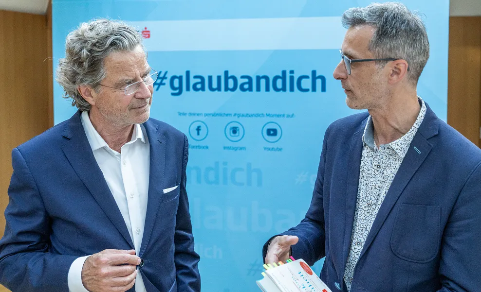 zwei Herren in Anzug schauen sich an