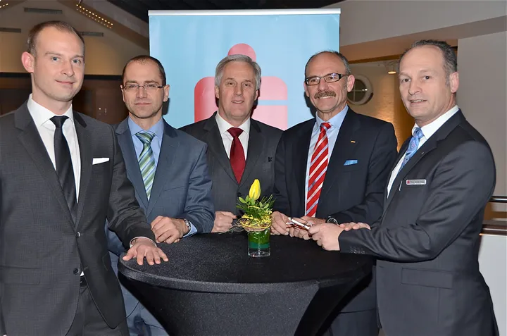fünf Männer stehen bei einem Stehtisch