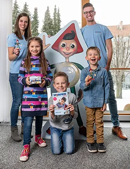 Kundenbetreuer Anita Rennhofer und Marco Grasz mit drei jungen  Sparefroh Club-Mitgliedern.