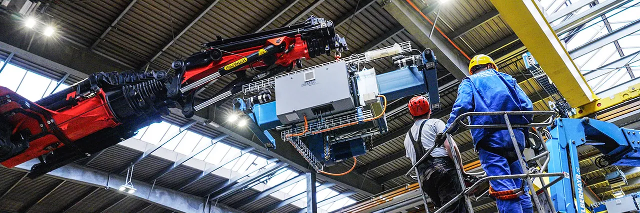 Arbeiter und ein Palfinger-Kran