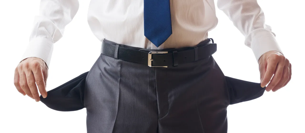 Mann im Anzug zeigt seine leeren Hosentaschen