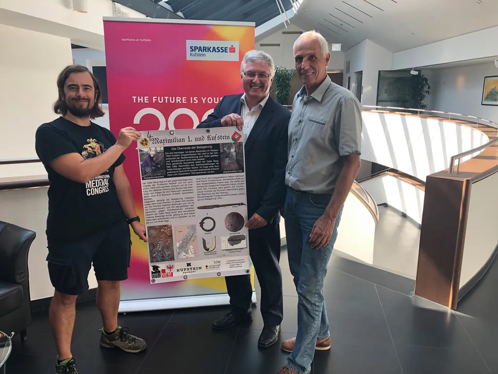 drei Männer mit Plakat in der Hand