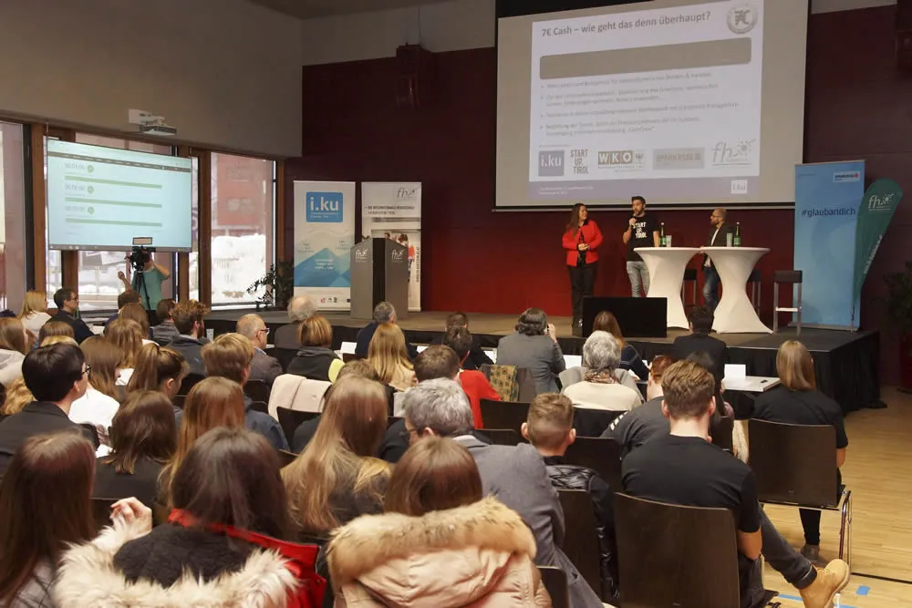 Personen hören sich einen Vortrag der FH an