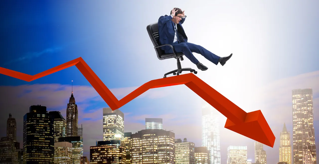 Mann auf Bürosessel über einen abwärts zeigenden Pfeil talwärts rasend