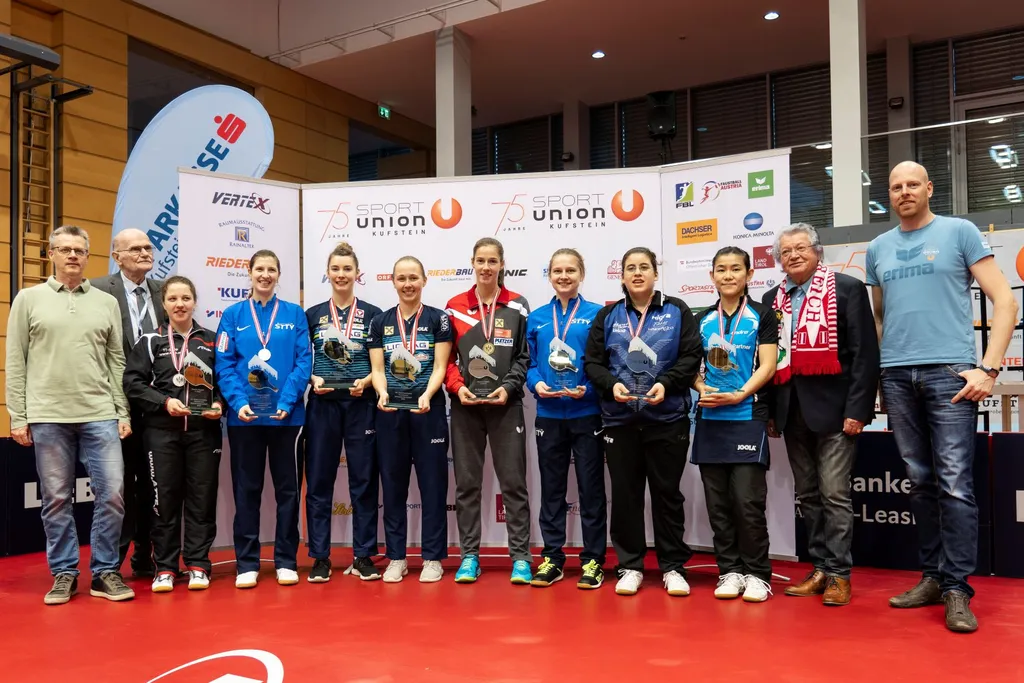 Sportler mit Medaille stehen nebeneinander und lächeln in die Kamera