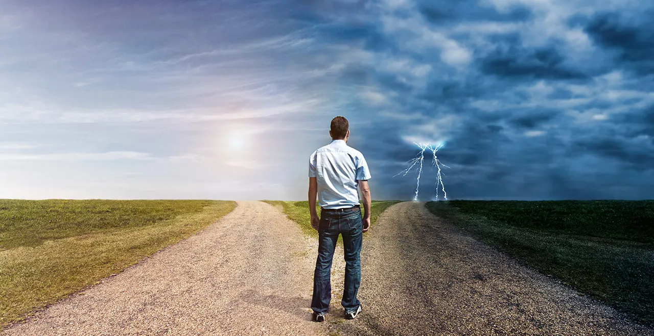Symbolbild - Mann steht vor einer Weggabelung, rechts Gewitter, links Schönwetter