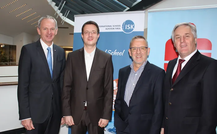 vier stehende Männer lachen in die Kamera